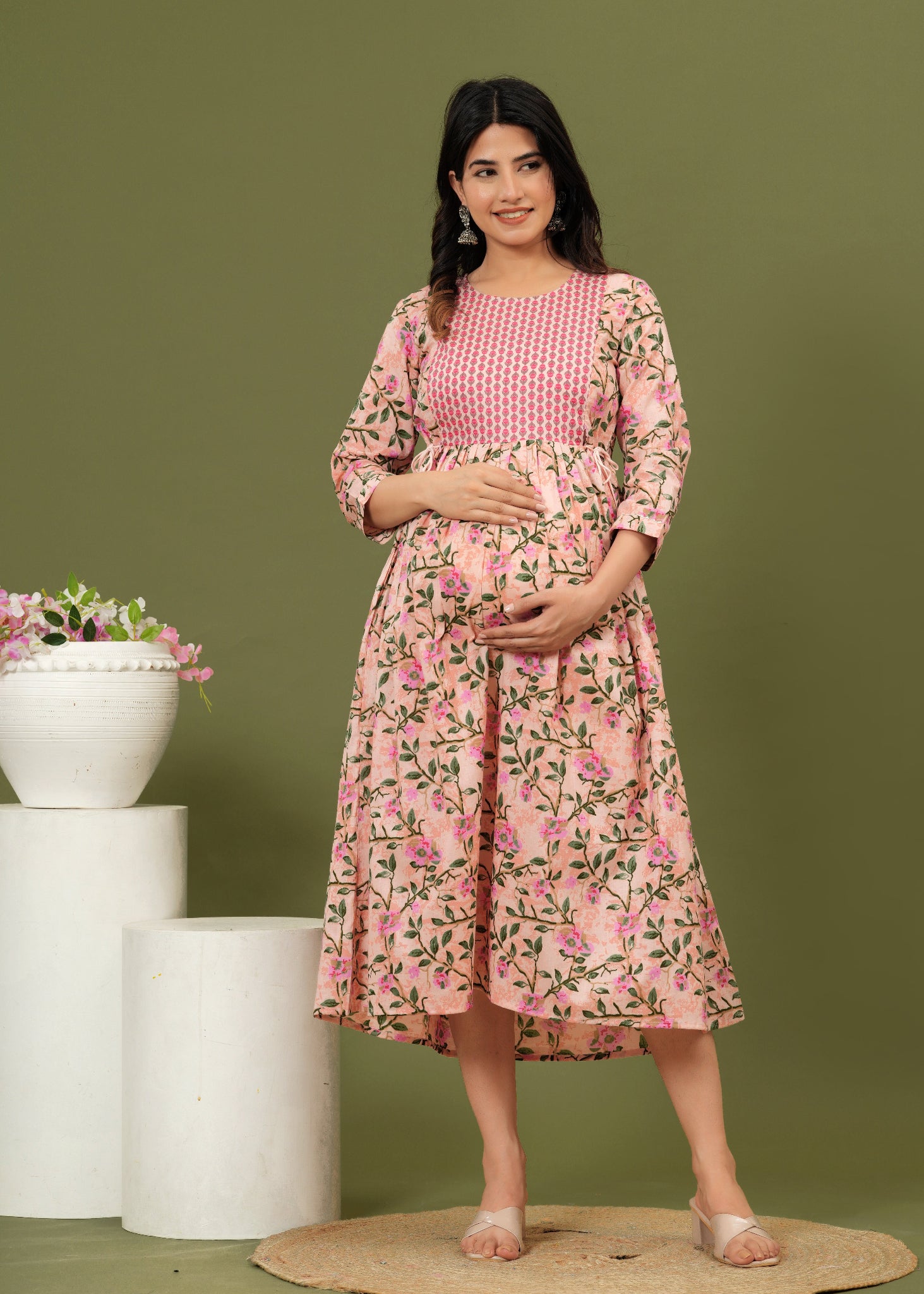 Woman wearing a pink floral dress against a green background